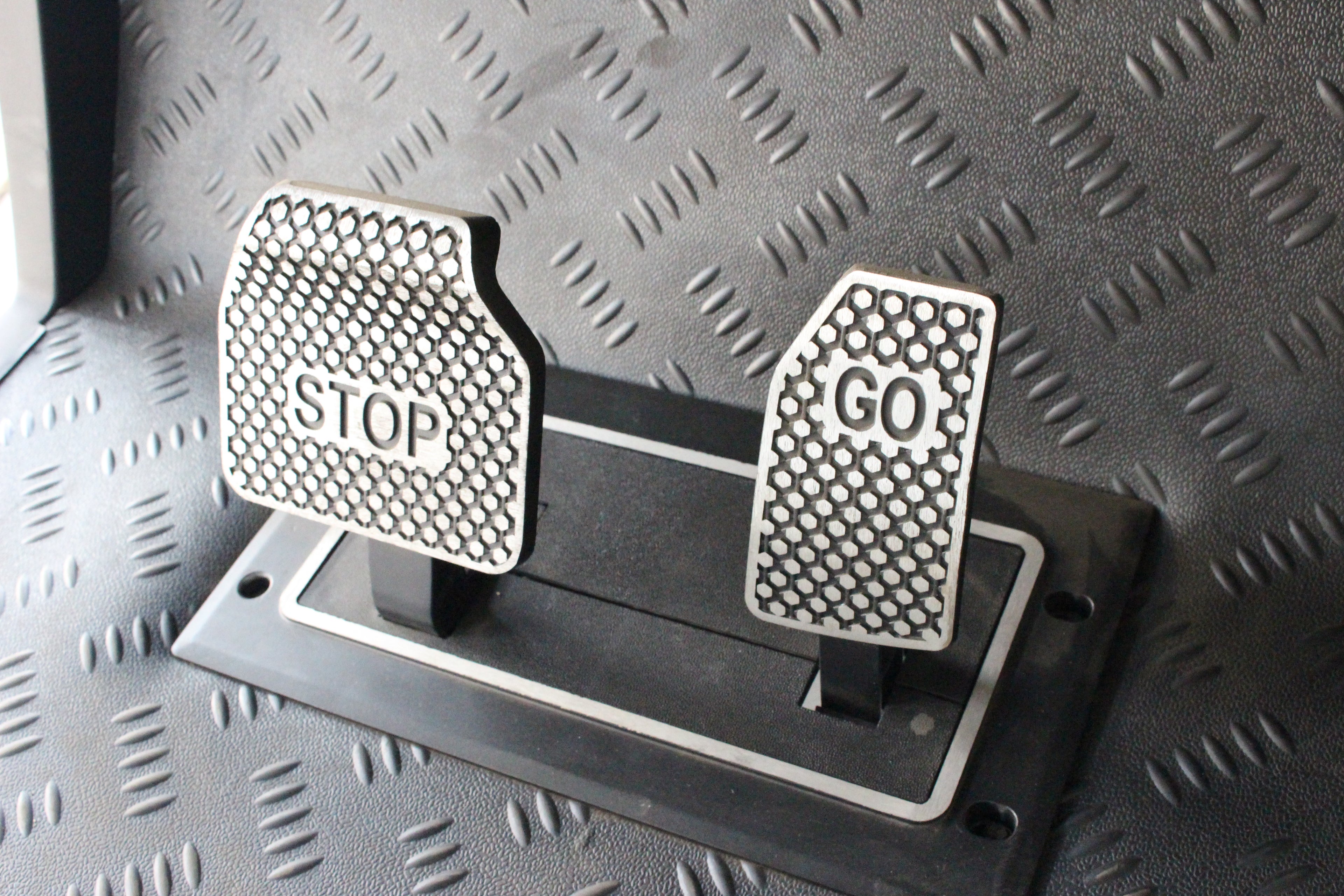 Metallic 'STOP' and 'GO' pedal covers on an electric golf cart 