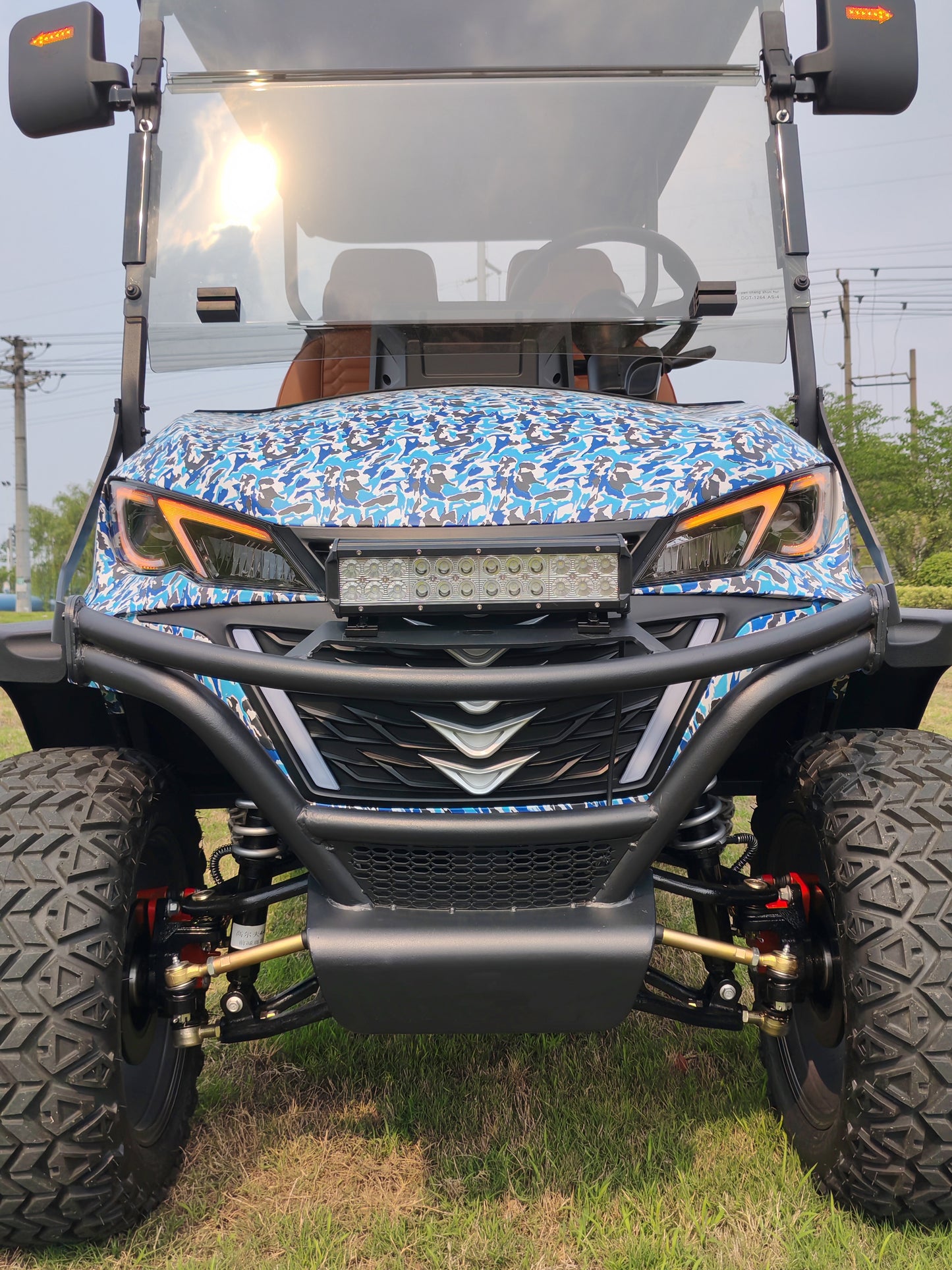 Front view of an off-road golf cart with a blue camouflage pattern on the hood.