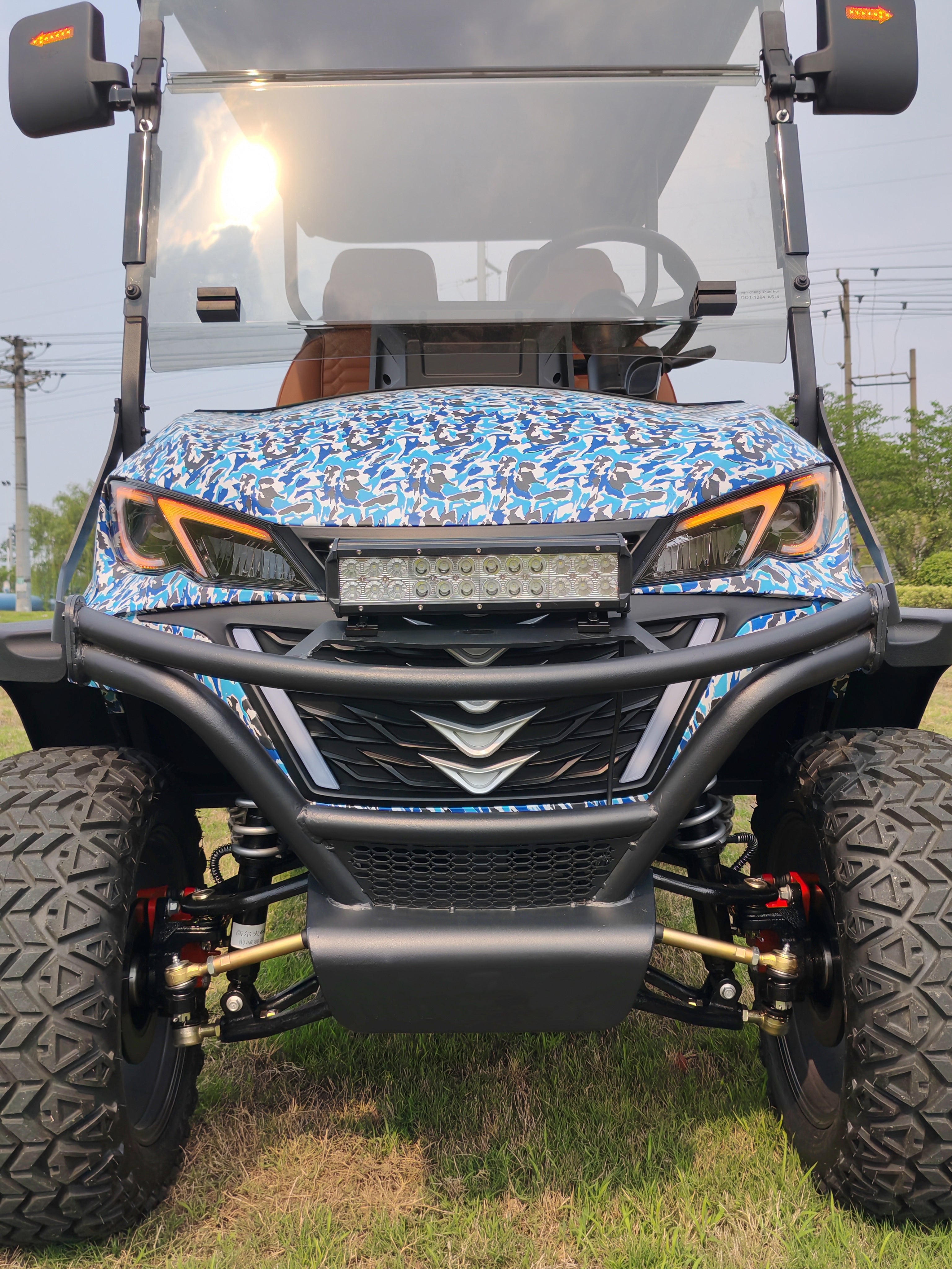 Front view of an off-road golf cart with a blue camouflage pattern on the hood.